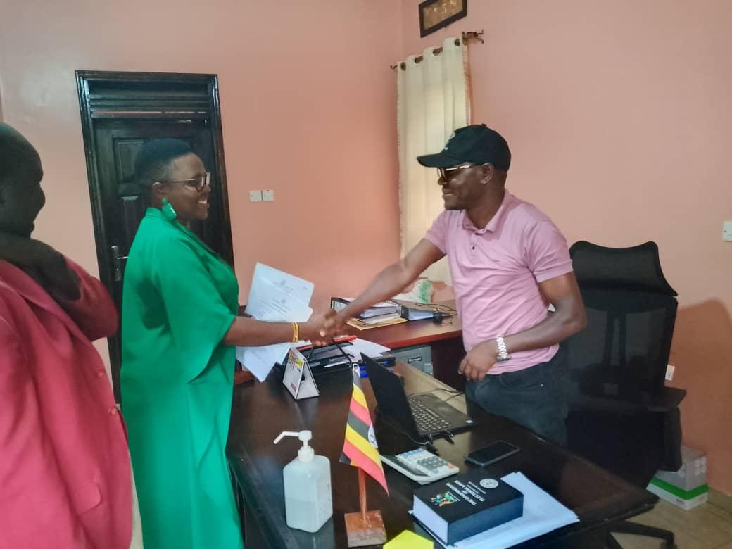 Emmanuel Ogwang, Zombo's Returning Officer hands over Nomination forms to Adong Sarah at Electoral Commission Offices in Paidha town council on October 2, 2025.