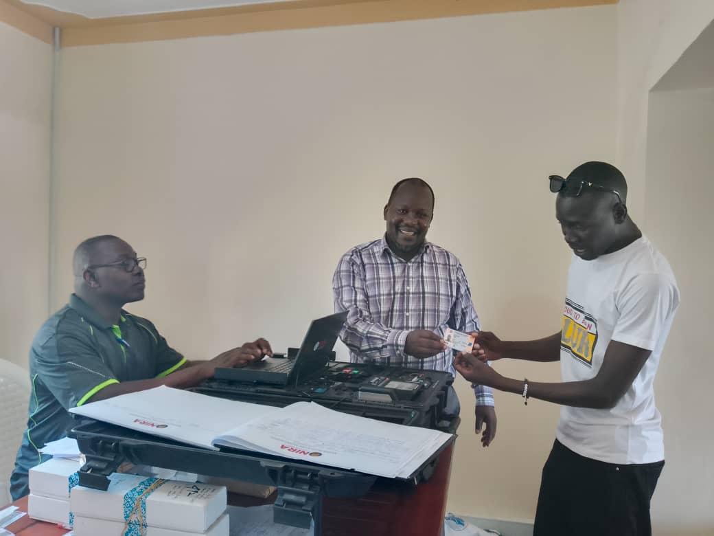Mr. Jimmy Uromcamu, the District Registration Officer for NIRA’s Zombo Branch, issued a renewed national ID to a recipient at NIRA's offices along Ofaka Road in Paidha Town Council On Wednesday, October 15, 2025.