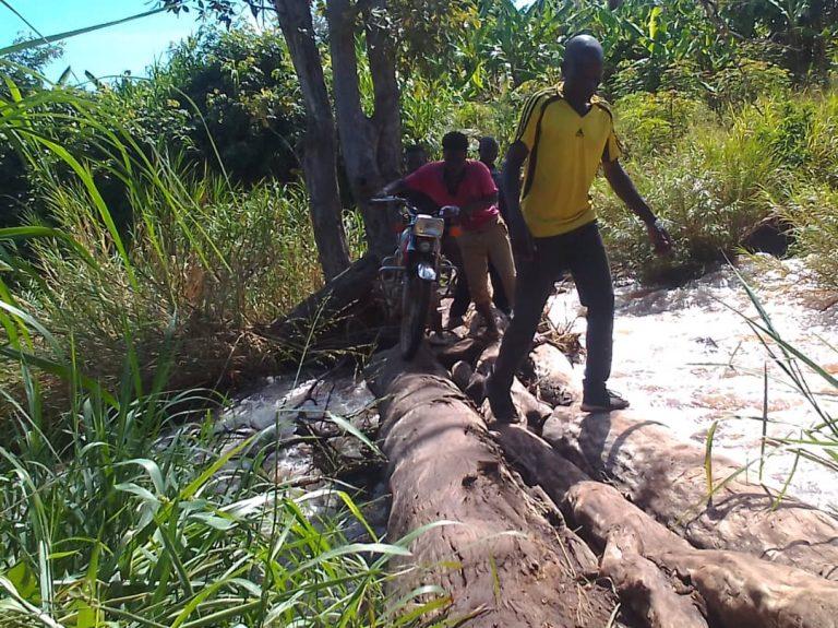 A group of local youths assists visitors by pushing or guiding their motorcycles across the bridge for a small fee.Photo/ Mike Rwothomio.