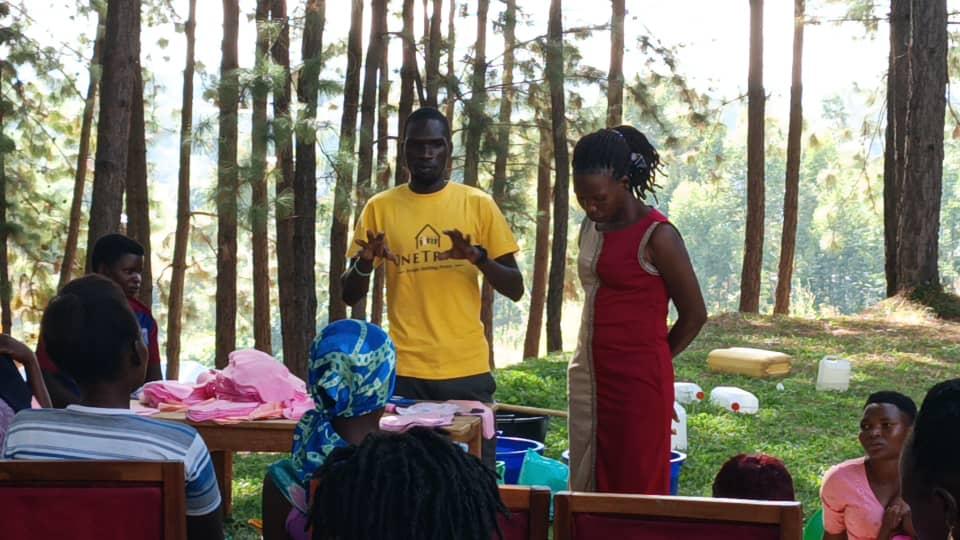 Facilitator Emmanuel Ociti takes the participants through the hands on skills in sanitary pads production