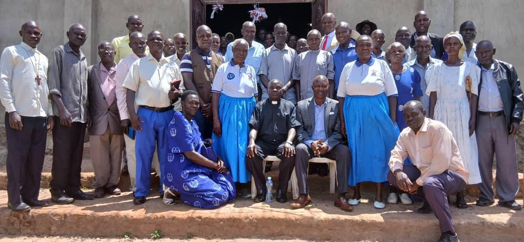 The Prime Minister (Jadipu) of the Alur Kingdom, Prince Lawrence Opar Angala, poses for a group photo seated next to the Archdeacon of Ukuru Archdeaconry, Nebbi Diocese, Venerable Wilfred Kumakech (wearing a clerical collar), alongside elders of St. Andrew's Church of Uganda (CoU) after the function.