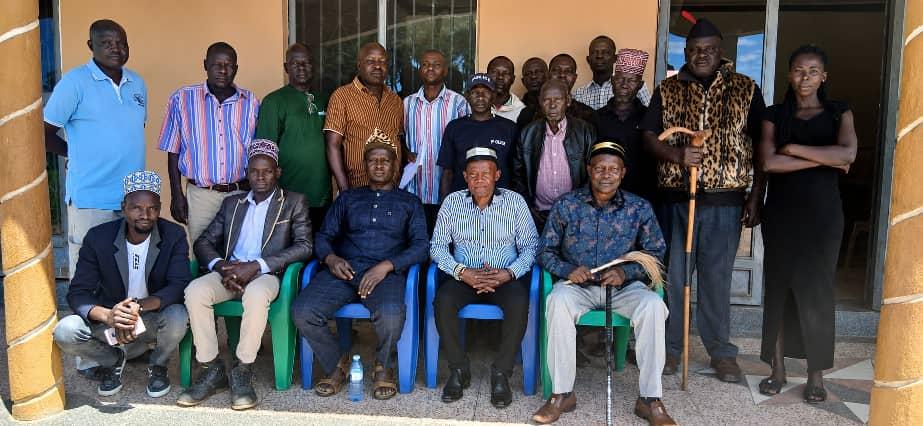 The Prime Minister (Jadipu), Prince Lawrence Opar Angala (seated right, holding a fly-whisk), poses for a group photo with the visiting delegation from the Alur Djuganda Chiefdom in the DRC, led by Chief Defalaise Okia Songa II (seated to Jadipu’s right in a white shirt), alongside Rwoth Wanok Owenja Joseph (seated second left) of Aringu Chiefdom, Rwoth Oyaki Jalukungu (seated centre in a black Kaunda suit) of Warr-Offaka Chiefdom, and members of the Atyak Royal Council headed by Vice Chairman Bosco Opoti (standing third left in a green shirt), following a meeting held at Kingston Guest House in Yamo Trading Centre.