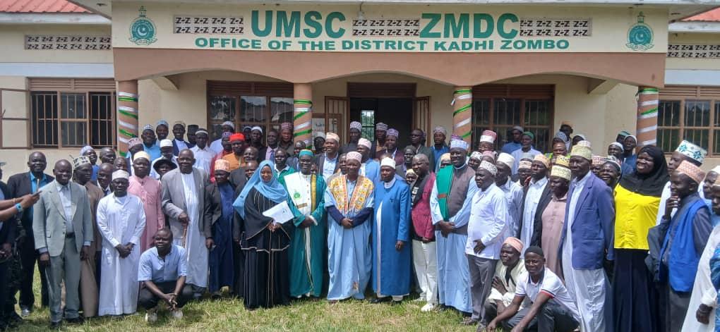 The Prime Minister (Jadipu) Prince Lawrence Opar Angala, new District Kadhi Kassim Abdullaziz Amin , the Mufti's representative Sheikh Ssali Imran, Rwoth Uledhire Nester Odaga Jalomayo of Ayuveni chiefdom and other officials pose for a group photo with muslim leaders from the newly created Zombo Muslim District, West Nile Muslim Region and Officials from UMSC after the installation ceremony.