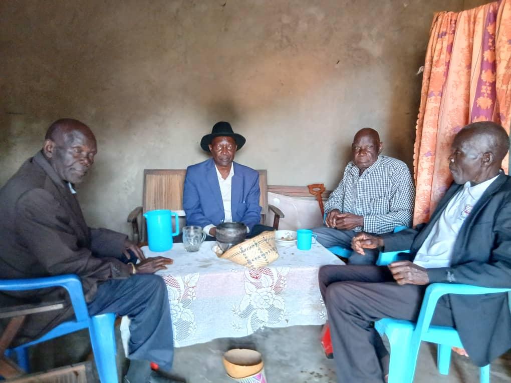 Jadipu Prince Lawrence Opar Angala (seated centre) sharing traditional meal with Mr Anthony Obima Ngomlokuju (on Jadipu's left) and Mr Joseph Opoka ( onJadipu's right) after successful mediation of the longstanding personal dispute that prevented the conclusion of an important Cultural ritual regarding Thumu Wanglei since 2006. The two reconciled and forgave each other and werecleansed through Yecu Ayiza ritual by Agulukongu Kwai Ocweda elders, Julam of Kaal Atyak Winam, according to Alur tradition in such circumstances.