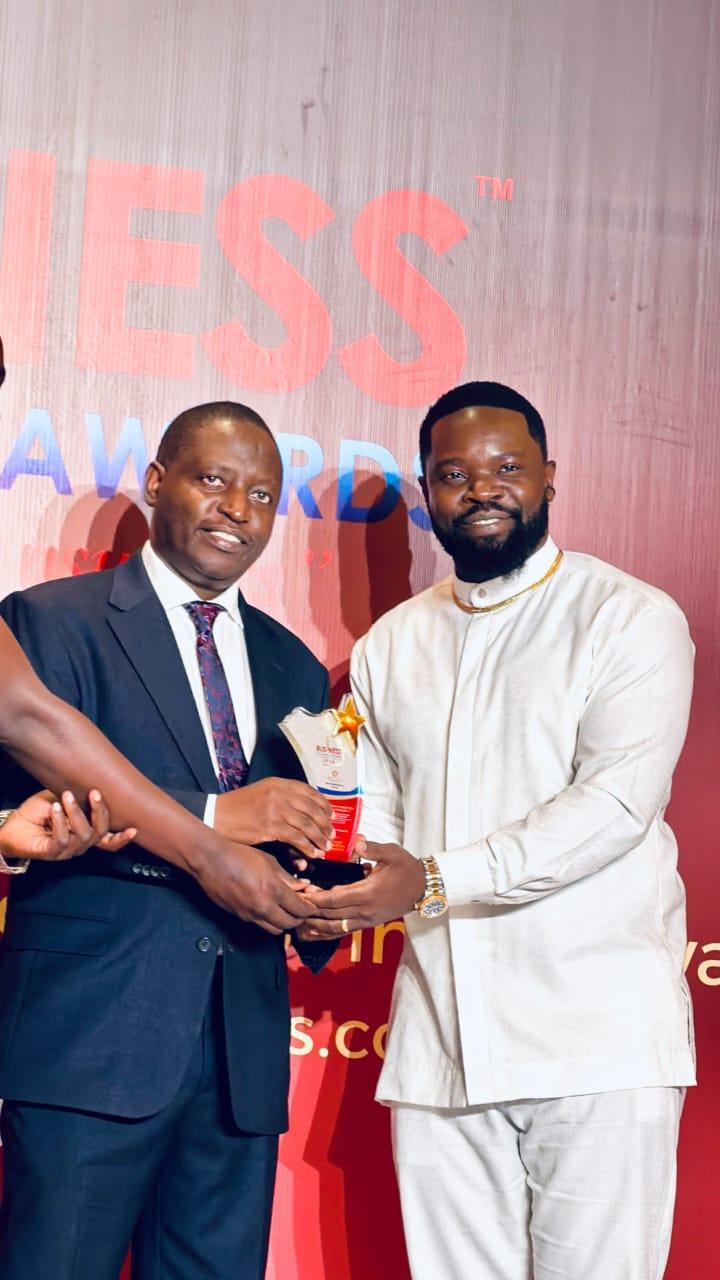 Feni Benard ( Right) received his award from Minister David Bahati.