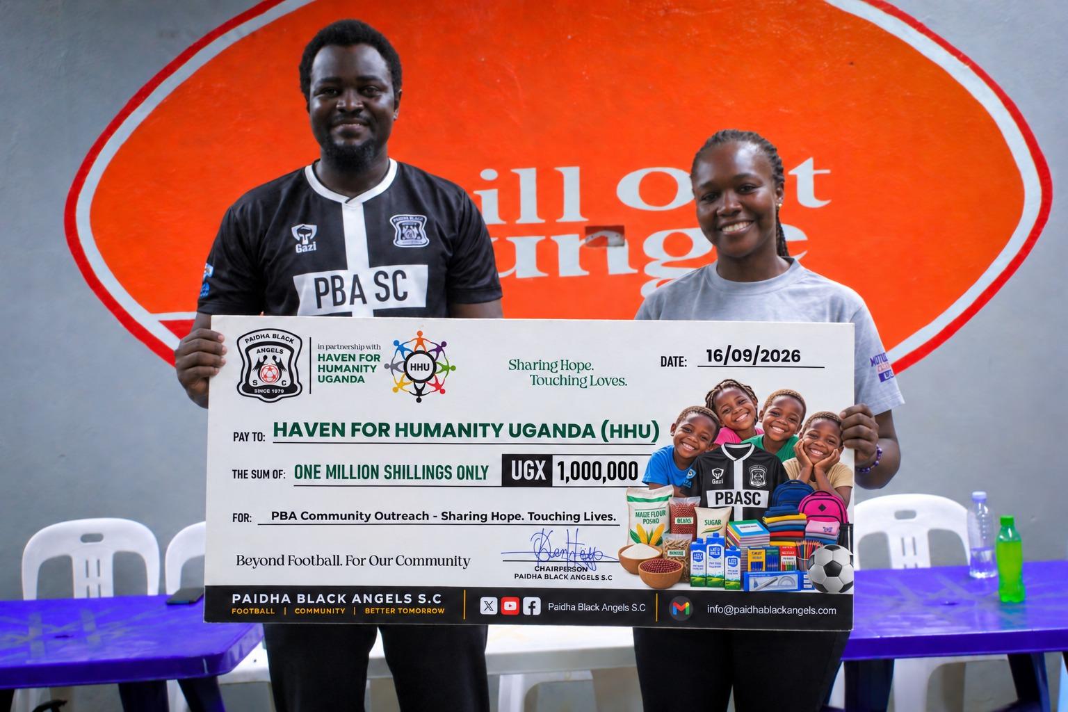 Paidha Black Angles SC Chairperson Keneth Owacgiu ( left) and Mercy Wanguic from Haven for Humanity -Uganda posed for a photo with a dummy cheque of Ugx 1 Million.